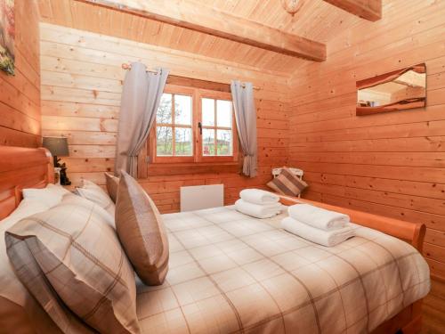 Ballinorig Lodge في Cleator Moor: غرفة نوم مع سرير في كابينة خشب