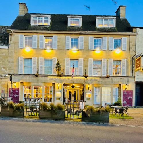 a large yellow building with a table in front of it at Crown & Cushion Hotel in Chipping Norton