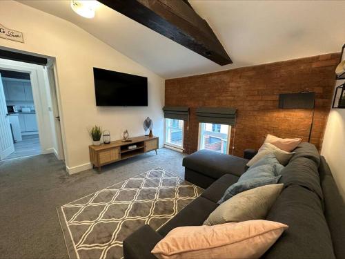 a living room with a couch and a flat screen tv at Cosy City Escape in Hull