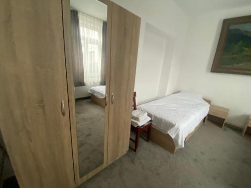 een kleine slaapkamer met een bed en een spiegel bij Twin Cloud Pădurea Verde in Timişoara