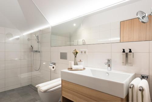 Baño blanco con lavabo y aseo en Hotel Johann Lauterach, en Lauterach