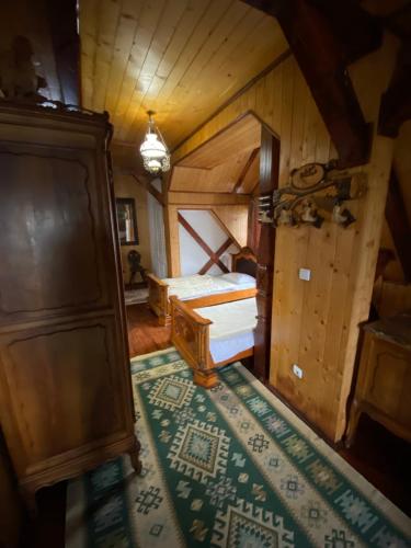 an attic bedroom with a bed and a rug at Pensiunea Andrei in Borşa