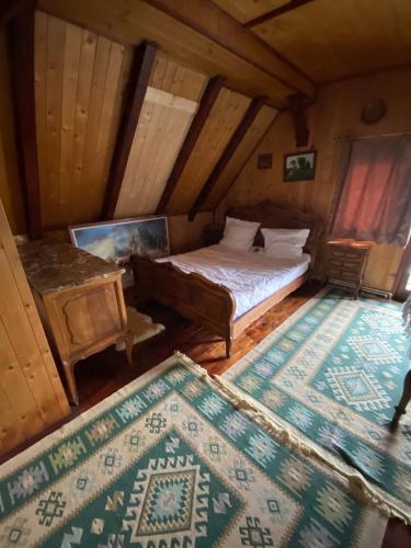 an attic room with a bed and a table at Pensiunea Andrei in Borşa