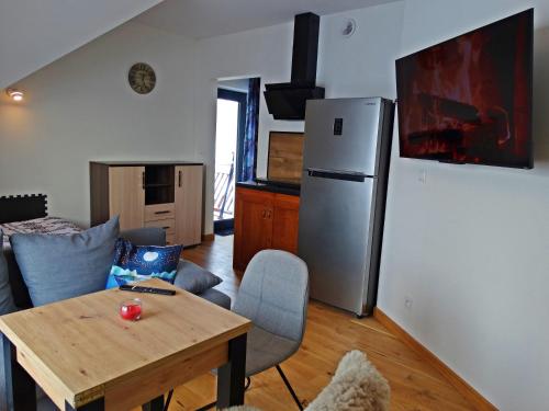 ein Wohnzimmer mit einem Tisch und einem Kühlschrank in der Unterkunft Apartamenty Widokówka in Grywałd