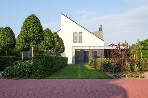 Biały dom z ogrodem i podjazdem w obiekcie Villa Zoutelande w mieście Zoutelande