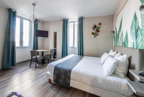a hotel room with a large bed and a table at Le Relais de la Poste in Gourdon