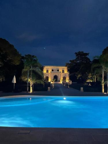 a large blue swimming pool in front of a building at Villa Di Noi in Arnesano
