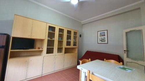 Zimmer mit einem Tisch und einigen Schränken in der Unterkunft Casa sud fronte mare in Follonica