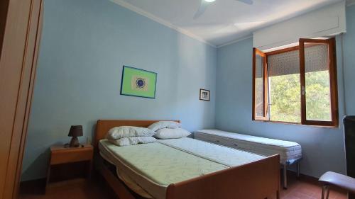 Schlafzimmer mit einem Bett und einem Fenster in der Unterkunft Casa sud fronte mare in Follonica