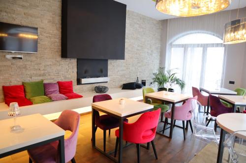 a restaurant with red and green chairs and a couch at Boutique hotel Relax In Style in Braşov