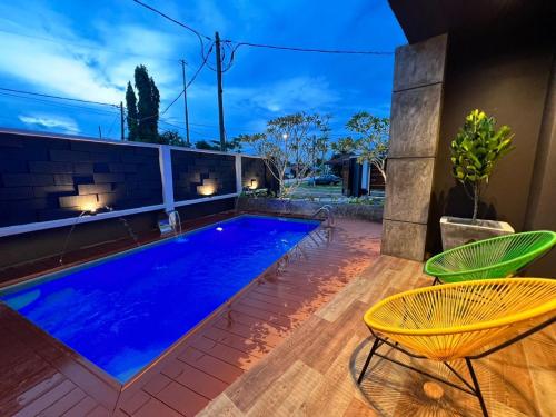 關丹的住宿－LA Villa Private Pool Kuantan，一个带两把椅子和一张桌子的游泳池