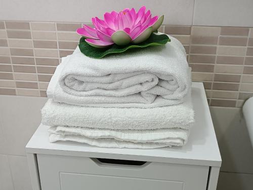 Una pila de toallas con una flor encima. en Casa da Sogno en Nápoles
