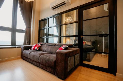 a living room with a couch and a large window at Stylish Loft Duplex Sunway Grid by Our Stay in Kampong Pendas