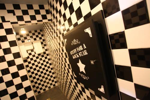 ein Bad mit einer schwarzen Tür mit Aufklebern darauf in der Unterkunft Hotel Apartamentos Rock Star in Taboadela