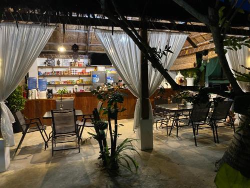 盧納將軍城的住宿－Siargao Residency by Privacy Group，一间设有白色窗帘和桌椅的餐厅