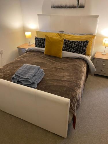 a large bed in a room with two lamps and two tables at Sedgefield luxury Apartments. in Sedgefield