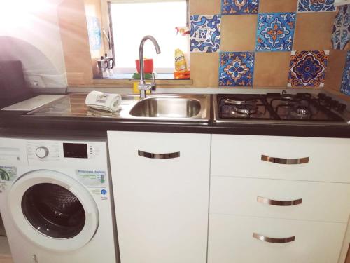 una cocina con fregadero y lavadora en Studio in pieno centro, en Capri
