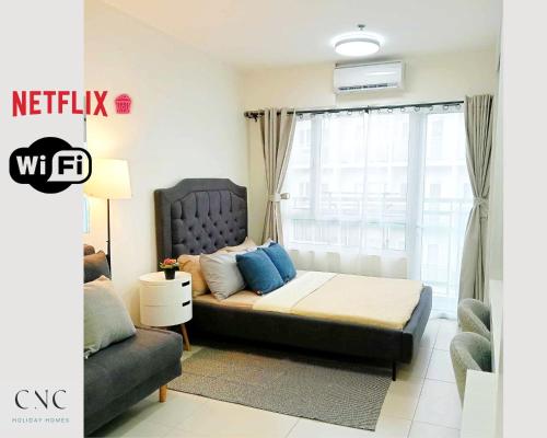 ein Schlafzimmer mit einem Bett, einem Sofa und einem Fenster in der Unterkunft CNC Tagaytay Staycation with Netflix in Tagaytay