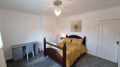 a bedroom with a bed and a table and a desk at Seaside 2 bed flat sleeps 6 in Lee-on-the-Solent