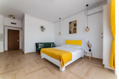 a bedroom with a bed with a yellow blanket at SOLMAR Studios in Năvodari