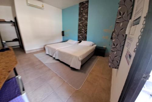 1 dormitorio con 1 cama en una habitación con paredes azules en Ban Lom Jen Homestay, en Chiang Rai