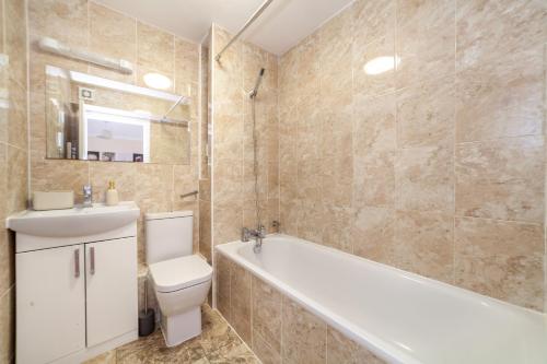 e bagno con vasca, servizi igienici e lavandino. di Lovely Studio Flat in Wimbledon w/ Free Parking a Londra