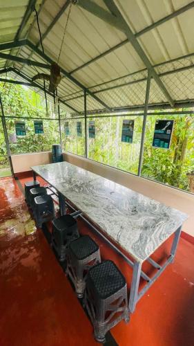 a table in a tent with stools around it at Caffeine Villa in Kaniyāmbetta