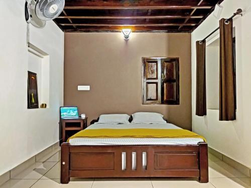 een slaapkamer met een bed en een televisie. bij Caffeine Villa in Kaniyāmbetta