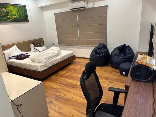 Zimmer mit einem Bett und zwei Sitzsäcken in der Unterkunft Ott Homes in Guwahati