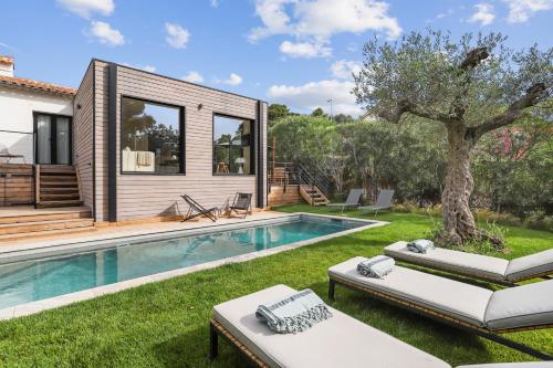 une maison avec une piscine et un arbre dans la cour dans l'établissement Villa La Temana, 18km de Saint-Tropez, à Cavalaire-sur-Mer