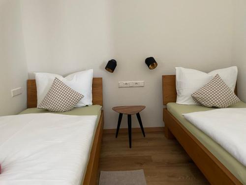 a room with two beds and a table in it at Weingut & Straußwirtschaft Vogel in Vogtsburg