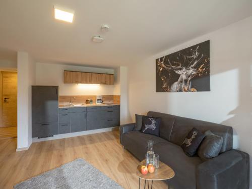 a living room with a couch and a kitchen at Berggasthof Bichlersee in Oberaudorf