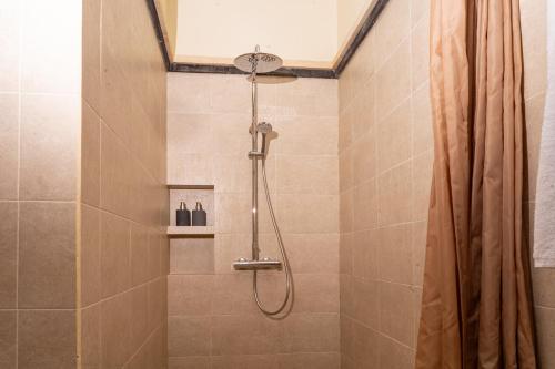 La salle de bains est pourvue d'une douche avec rideau de douche. dans l'établissement tiny's house, à Ubud