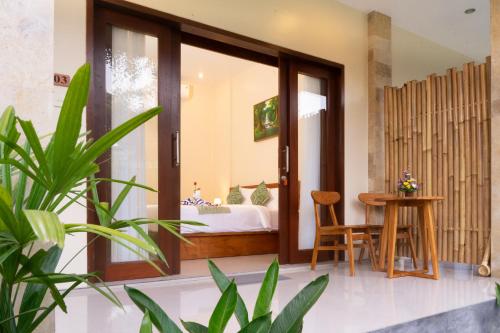 a room with a bed and a table with a table at tiny's house in Ubud