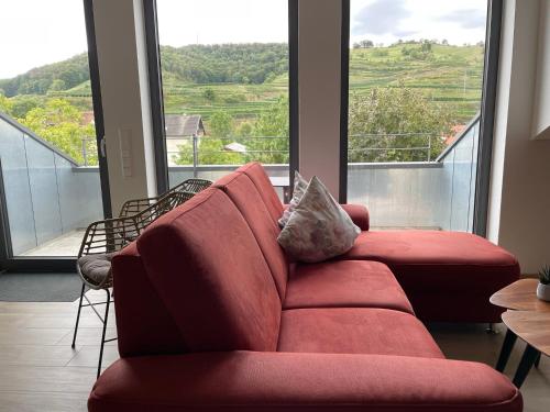 a red couch in a room with a large window at Weingut & Straußwirtschaft Vogel in Vogtsburg
