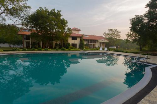 a swimming pool in front of a house at Hotel Chenra in Kataragama