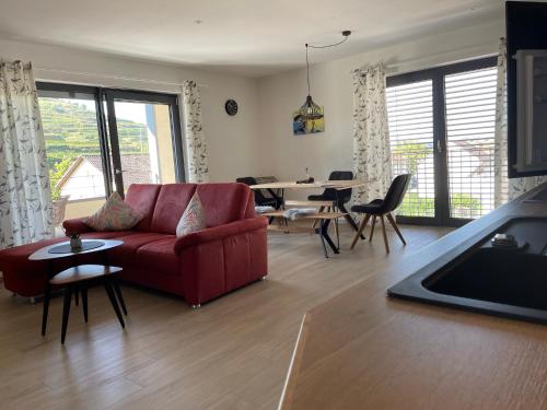 a living room with a red couch and a table at Weingut & Straußwirtschaft Vogel in Vogtsburg