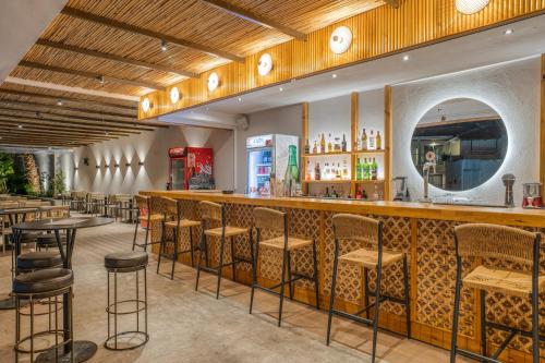 a restaurant with a bar with stools at Hotel Papillon in Argassi