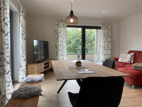 a living room with a table and a red couch at Weingut & Straußwirtschaft Vogel in Vogtsburg