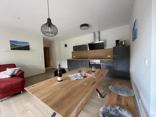 a living room with a wooden table and a red couch at Weingut & Straußwirtschaft Vogel in Vogtsburg