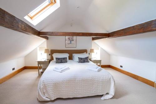 a bedroom with a large bed in a attic at Pass the Keys - Cotswolds Farmhouse - Sleeps 10 - Stunning garden in Moreton in Marsh