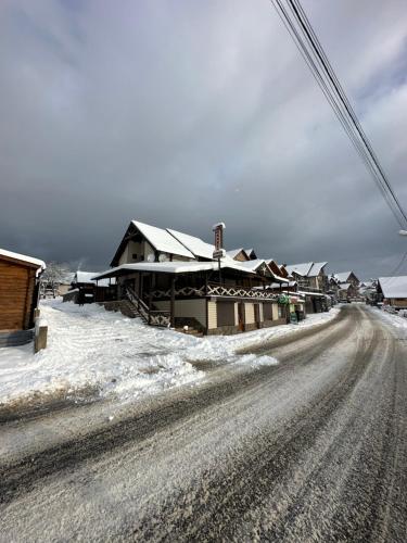 a snow covered road in front of a house at Palaga Bukovel in Bukovel