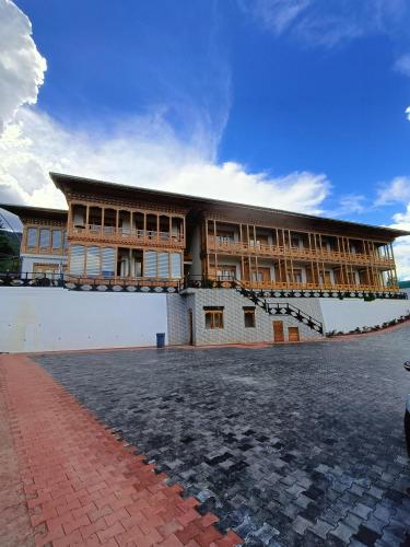 a large building with a brick courtyard in front of it at Jagathang Village Inn in Paro