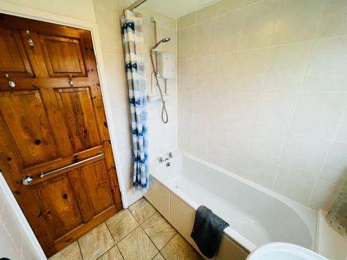 a bathroom with a bath tub and a toilet at 2 Bedroom Chalet SB11, Sandown Bay, Dog Friendly in Sandown