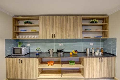 a kitchen with wooden cabinets and a microwave at People Guest House in Bishkek