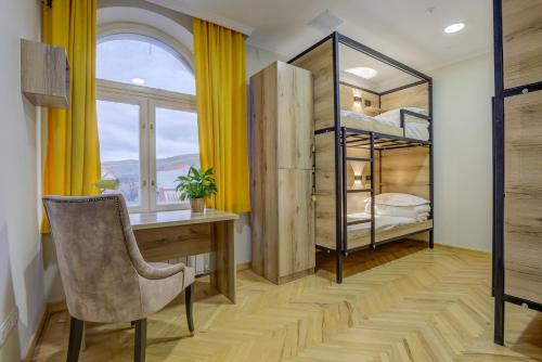 a bedroom with a desk and a bunk bed at People Guest House in Bishkek