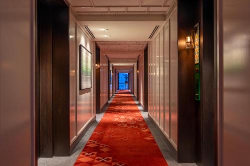 a long corridor with a red carpet in a building at Hotel Indigo Kuala Lumpur on the Park by IHG in Kuala Lumpur