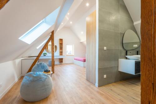 La salle de bains mansardée est pourvue d'un lavabo et d'un miroir. dans l'établissement Magnifique maison neuve, à Lingolsheim