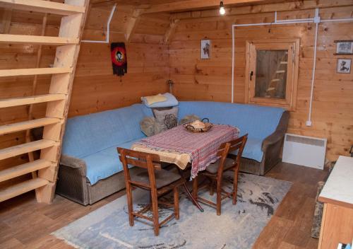 una habitación con una mesa y una cama en una cabaña en Forest fruit Jelovica en Berane