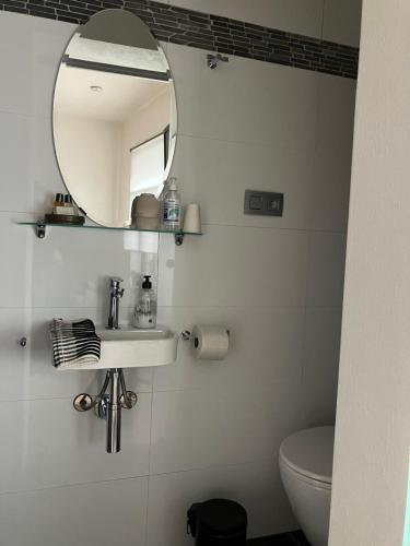 a bathroom with a mirror and a sink and a toilet at B&B My Suite Home in Bruges